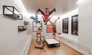 Tre personer gör handstående i ett rum där allt är upp och ner. En affisch med texten "paradox museum" syns på väggen.