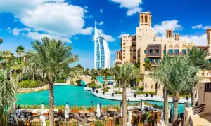 En vacker vy över Dubai med palmer, turkost vatten och Burj Al Arab. Perfekt för att planera dina aktiviteter i Dubai.