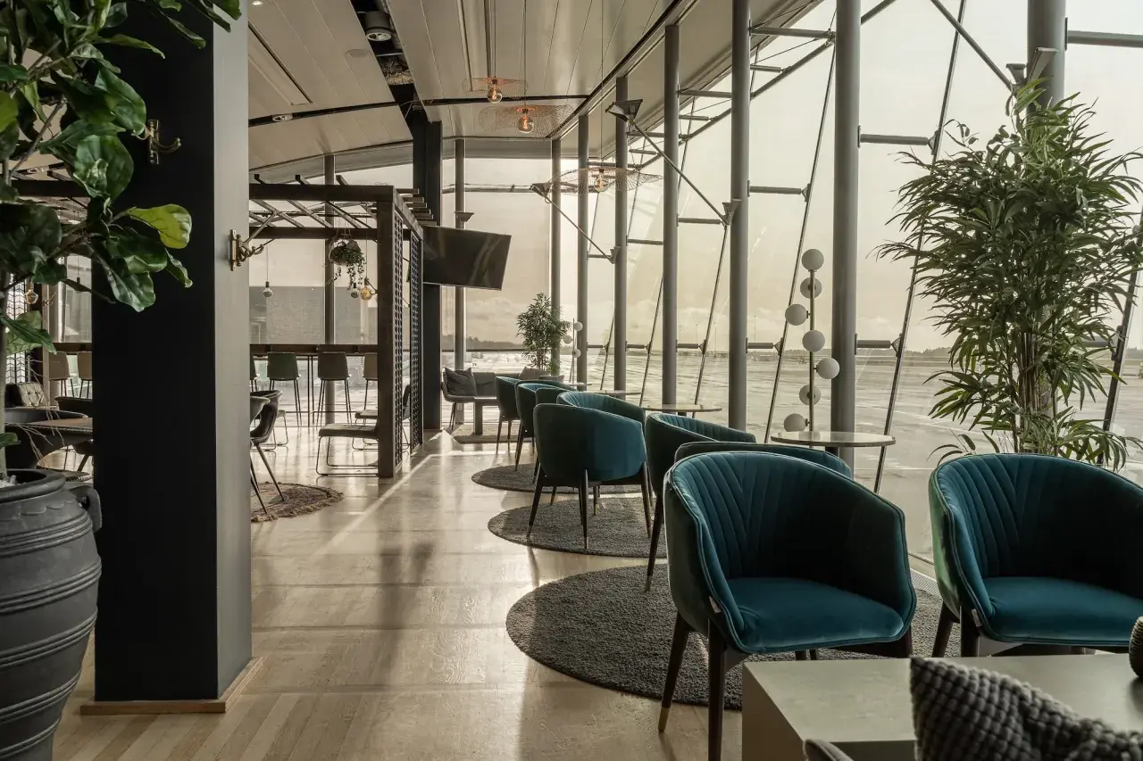 Bekväma fåtöljer i en lounge vid Landvetter flygplats. Stora fönster ger utsikt över landningsbanan.