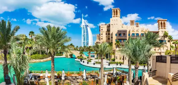 En vacker vy över Dubai med palmer, turkost vatten och Burj Al Arab. Perfekt för att planera dina aktiviteter i Dubai.