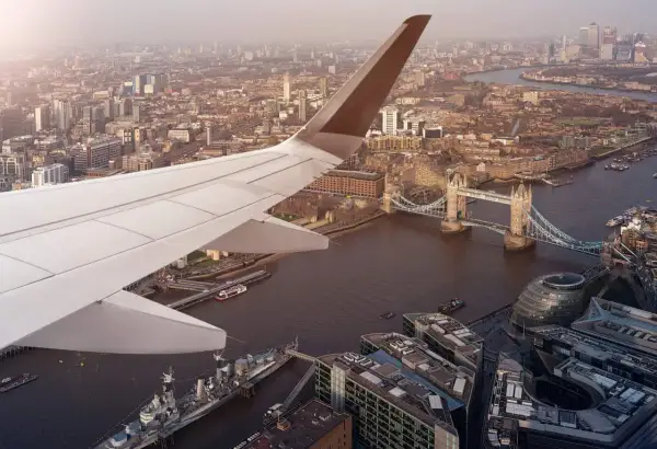 Flygplansvinge över London med Tower Bridge och floden Themsen. En vy som påminner om ankomsten till en av Londons flygplatser.